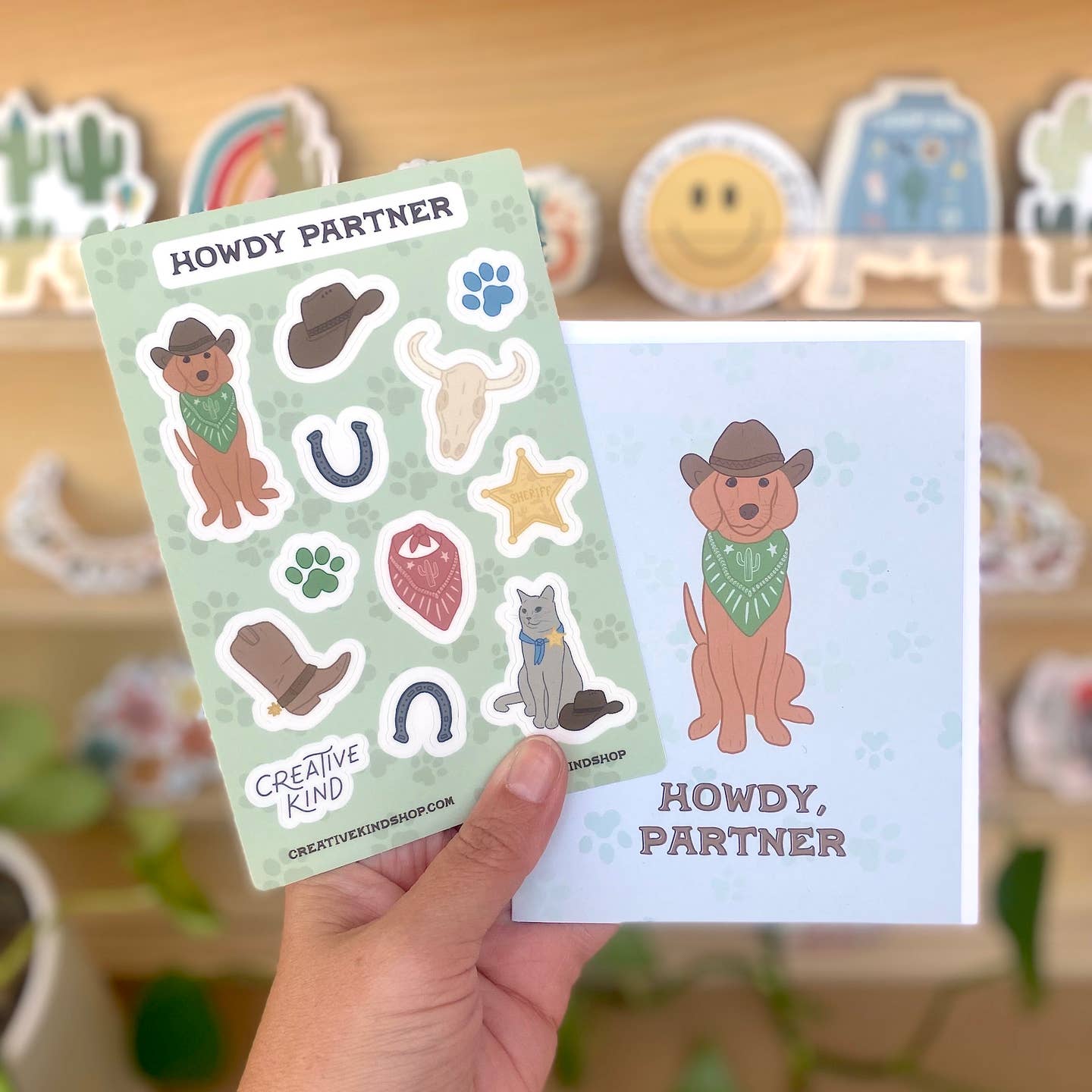 Sticker sheet with cowboy-themed stickers and a matching card held by a hand.